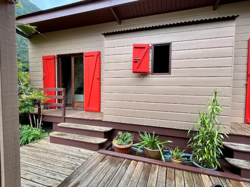 Façade en cryptoméria de la chambre d'hôtes Les Mimosas, volets rouges, La Réunion
